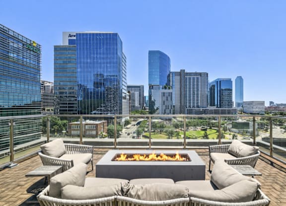A fire pit sits in the middle of a patio with bean bag chairs around it.