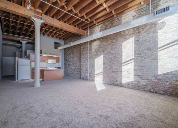 A room with a brick wall and a wooden ceiling.