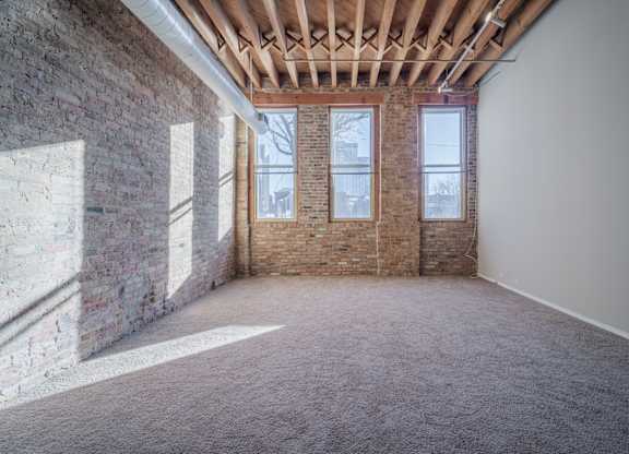 A room with a brick wall and a carpeted floor.