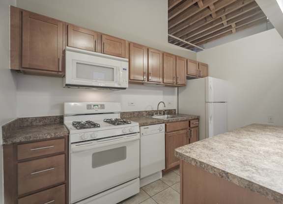 A kitchen with a white stove and brown cabinets.