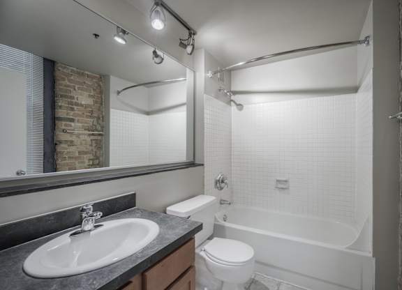 A bathroom with a white toilet, sink, and bathtub.