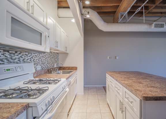 A kitchen with a white stove and a counter top.
