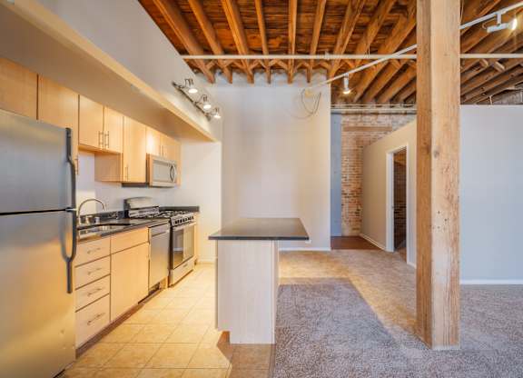A kitchen with a refrigerator, stove, and microwave.