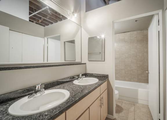 A bathroom with two sinks and a shower.