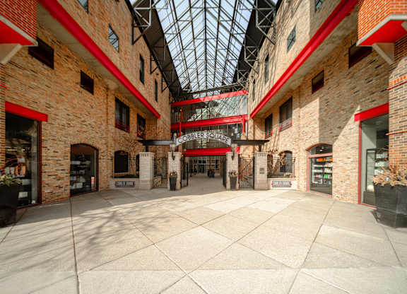 The interior of a building with a glass roof and brick walls.