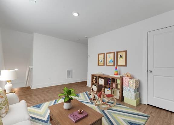 A living room with a white couch, a wooden coffee table, and a striped rug.