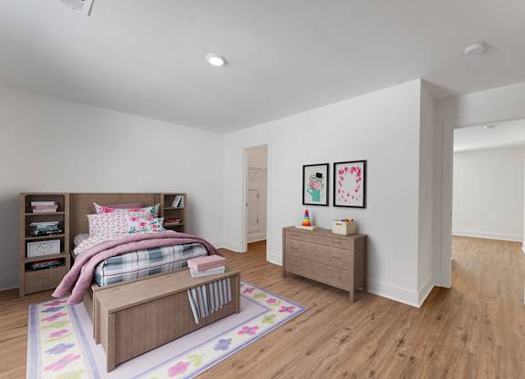 A bedroom with a bed, dresser, and bookshelf.