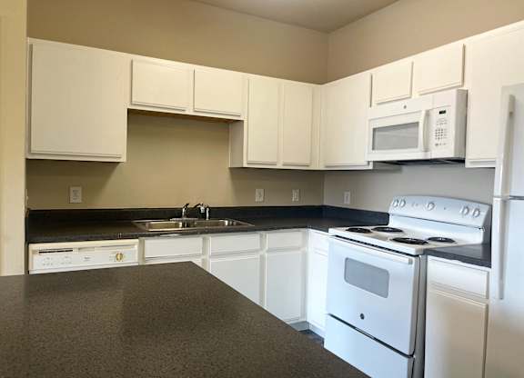 A kitchen with white appliances and cabinets.