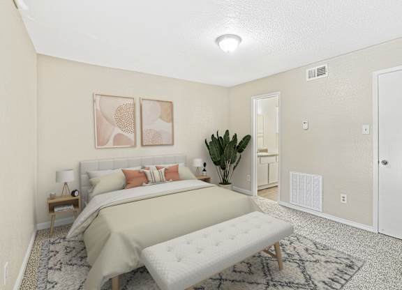 A bedroom with a large bed and a bench in the middle of the room.