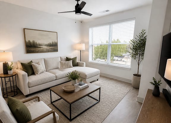 A living room with a white couch, a wooden chair, a coffee table, and a painting on the wall.