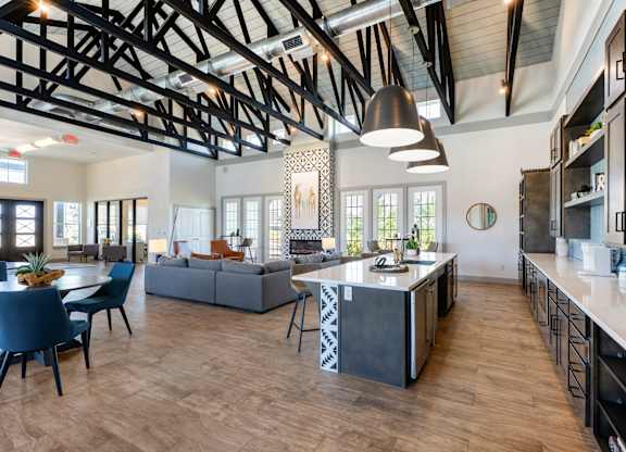 A modern kitchen with a large island and a dining table with chairs.