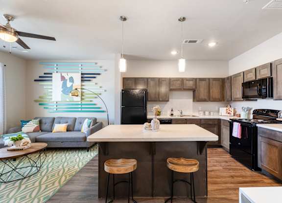 A modern kitchen with a bar stool in front of the island.