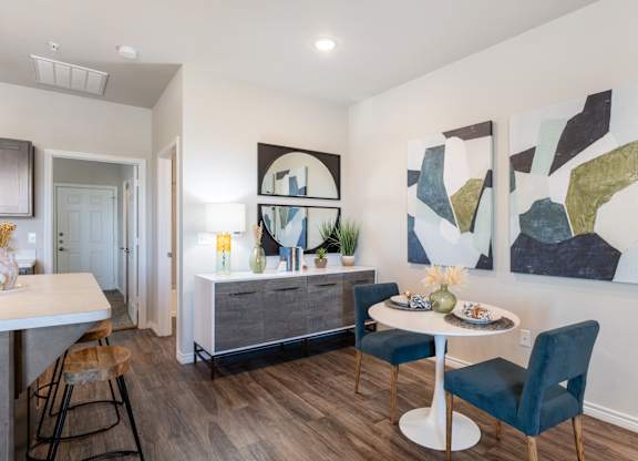 A dining room with a white table and blue chairs.