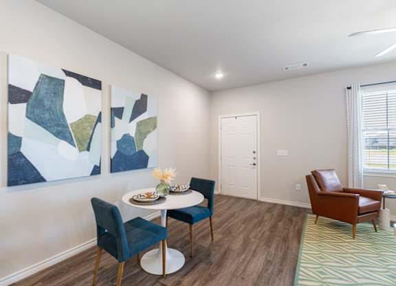 A dining room with a white table and chairs.