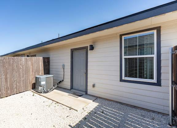 A house with a grey door and a window with blinds.
