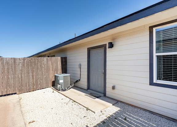 A house with a grey door and a window with blinds.