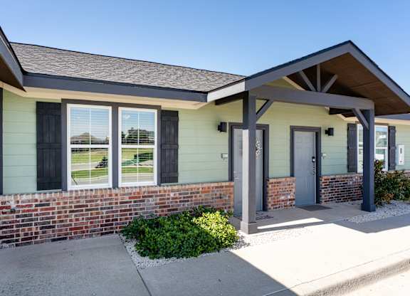 A house with a grey roof and a brick wall.