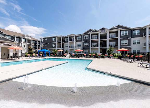 A large swimming pool in front of apartment buildings.