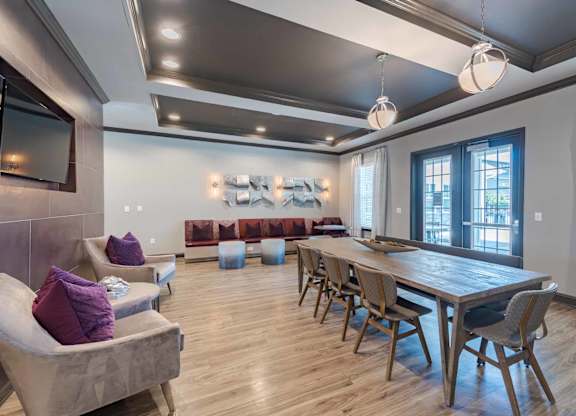 A modern dining room with a long table and chairs.