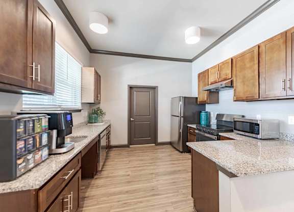 A kitchen with brown cabinets and a white countertop.