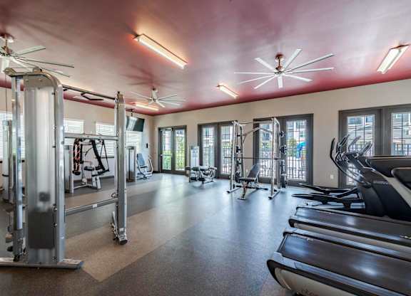A gym with treadmills, weights, and exercise equipment.