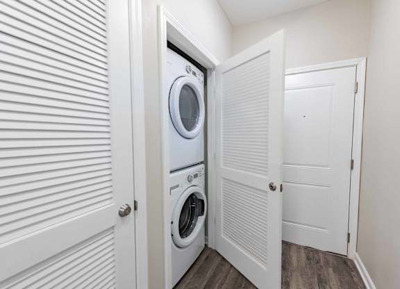 A white washing machine is in a small laundry room.