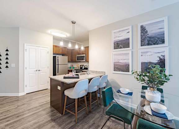 A kitchen with a dining table and chairs.