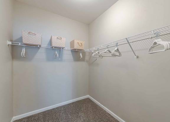 A laundry room with a clothes dryer and a shelf with baskets on it.