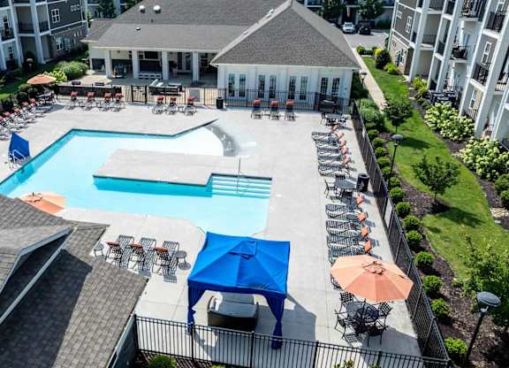 A large swimming pool surrounded by lounge chairs and umbrellas.