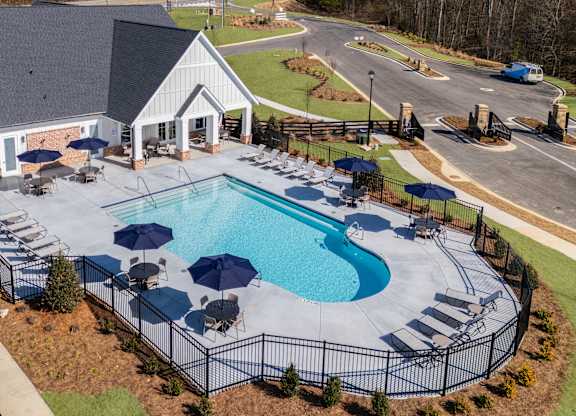 A large outdoor swimming pool surrounded by a black fence.