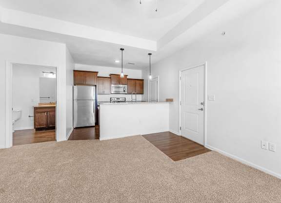 A kitchen with white walls and a refrigerator.