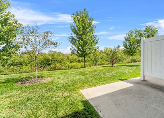 A white fence is on the right side of a driveway.