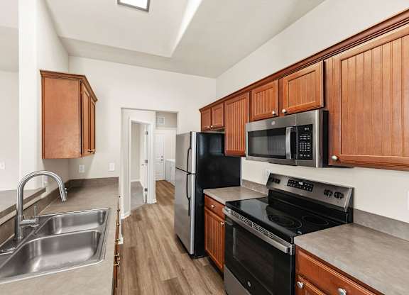 A kitchen with wooden cabinets and black appliances.