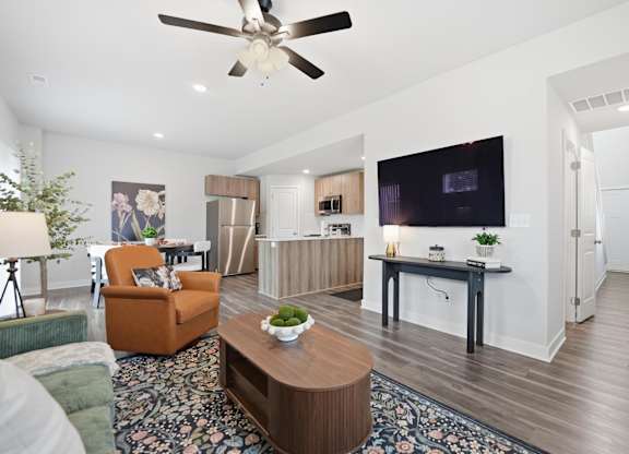A living room with a brown coffee table and a ceiling fan.