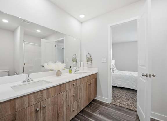 A white bathroom with a vanity and a mirror.