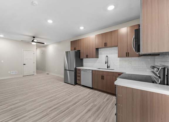 A kitchen with wooden cabinets and a refrigerator.