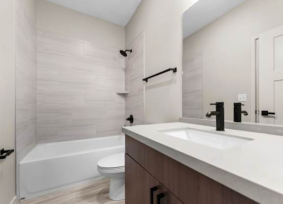 A white bathroom with a white tub and sink.