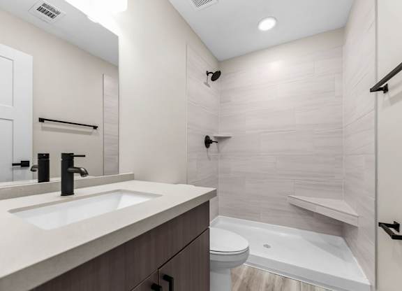 A modern bathroom with a white sink and a white bathtub.