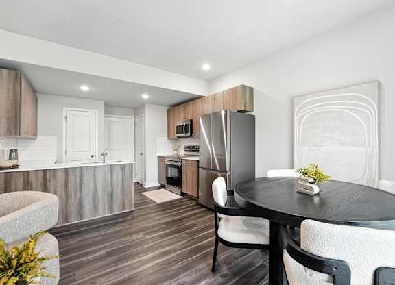 A modern kitchen with a dining table set for two.