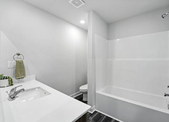 A white bathroom with a sink, toilet, and bathtub.
