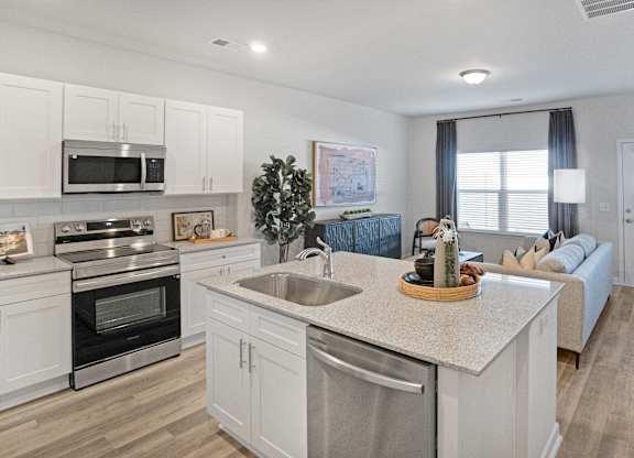 A modern kitchen with white cabinets and stainless steel appliances.