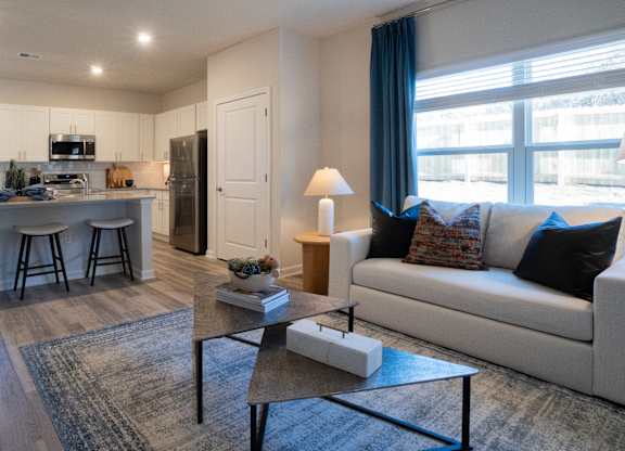 A well-lit living room with a white couch and a coffee table.