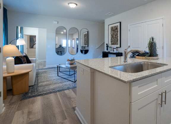 A modern kitchen with a white countertop and a sink.