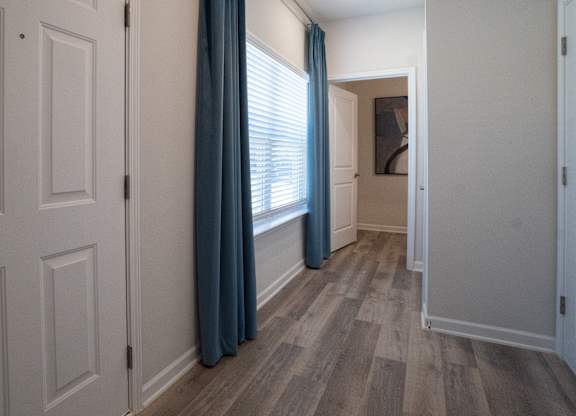 A hallway with white doors and a blue curtain.