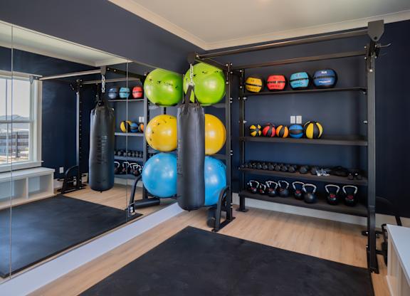 A gym with a variety of equipment including kettlebells and exercise balls.