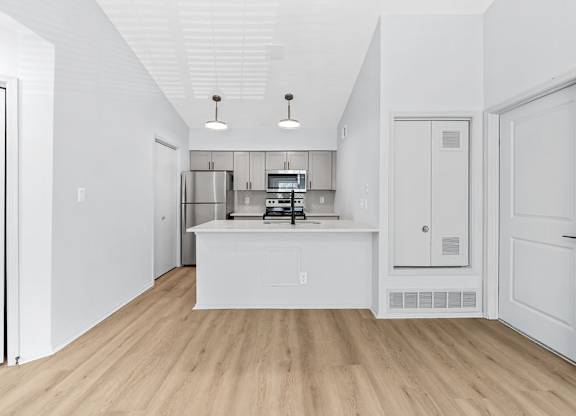 A kitchen with white cabinets and a white island.