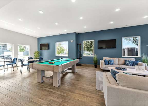 A room with a pool table and a couch.
