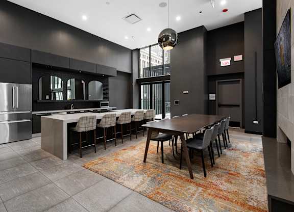 A modern kitchen with a large island and a dining table set for six.