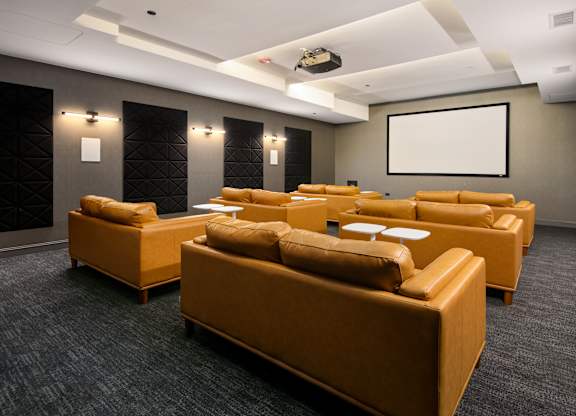 A room with a screen and couches.