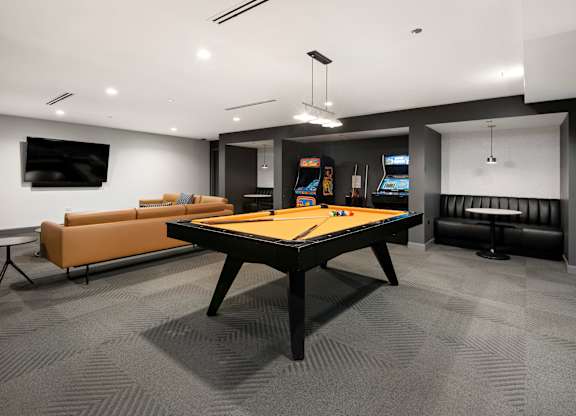 A room with a pool table and a couch.